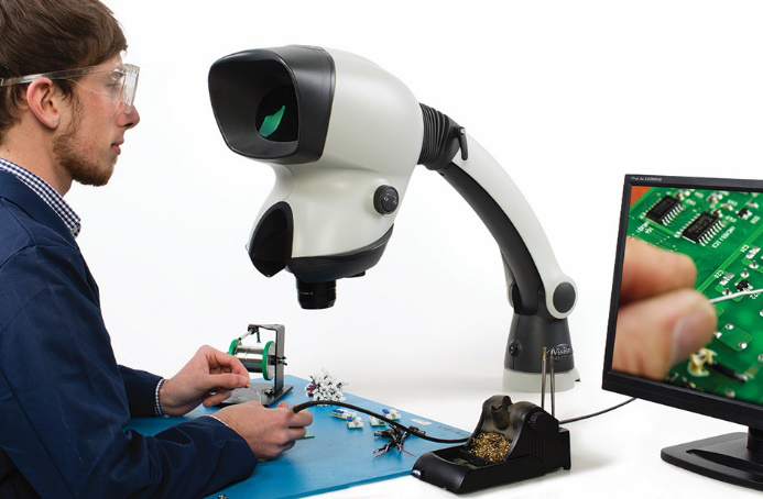 Man soldering a PCB viewing with Mantis Stereo Microscope