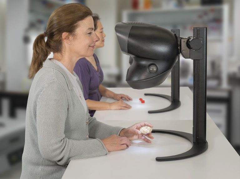 OPTA-stereo-microscope-with-different-operators OPTA stereo microscope used by two women technicians